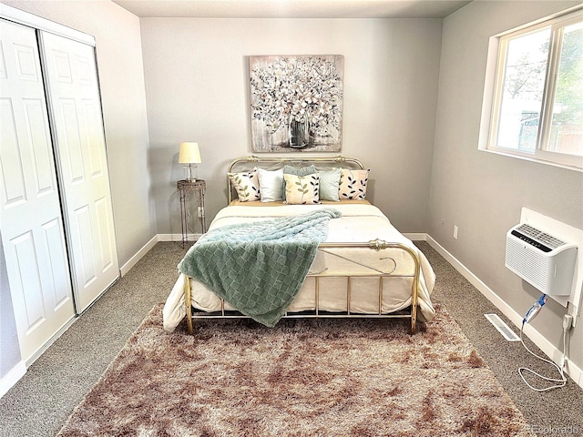 bedroom featuring dark colored carpet, an AC wall unit, and a closet