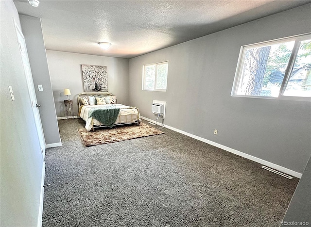 bedroom with dark carpet and a textured ceiling