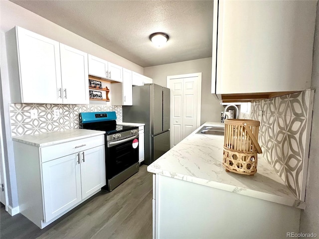 kitchen with white cabinets, stainless steel appliances, hardwood / wood-style flooring, and sink