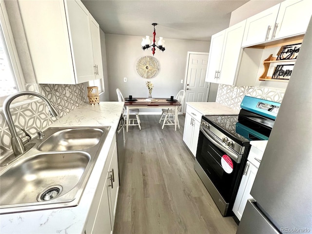 kitchen with backsplash, white cabinetry, sink, and appliances with stainless steel finishes