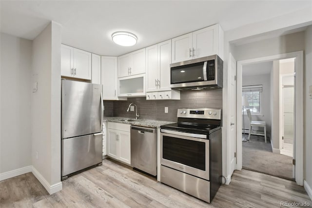5875 E Iliff Ave Unit 108, Denver, CO 80222 - kitchen featuring stainless steel appliances, a sink, white cabinetry, and light wood-type flooring