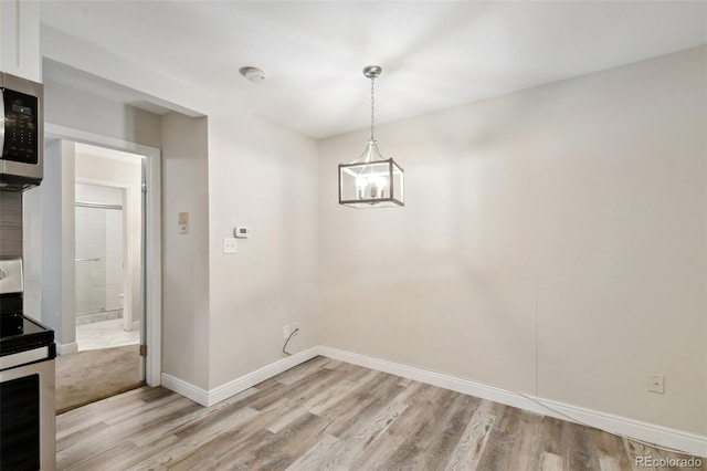 5875 E Iliff Ave Unit 108, Denver, CO 80222 - unfurnished dining area featuring light wood-style floors, baseboards, and a chandelier