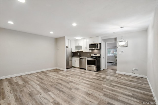 5875 E Iliff Ave Unit 108, Denver, CO 80222 - kitchen with appliances with stainless steel finishes, white cabinetry, baseboards, light wood-type flooring, and recessed lighting