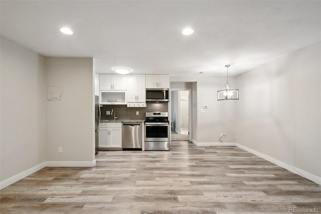 5875 E Iliff Ave Unit 108, Denver, CO 80222 - kitchen with stainless steel appliances, white cabinetry, a sink, baseboards, and recessed lighting