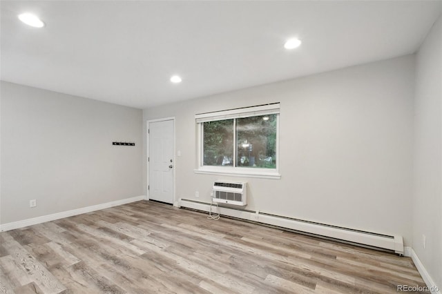 5875 E Iliff Ave Unit 108, Denver, CO 80222 - empty room featuring a baseboard radiator, wood finished floors, recessed lighting, a wall mounted air conditioner, and baseboards