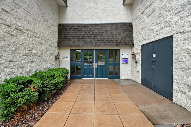 5875 E Iliff Ave Unit 108, Denver, CO 80222 - entrance to property featuring french doors, a shingled roof, and stucco siding