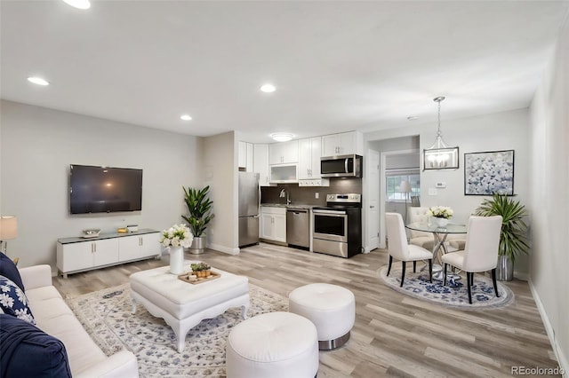 5875 E Iliff Ave Unit 108, Denver, CO 80222 - living room featuring light wood-type flooring, recessed lighting, and baseboards