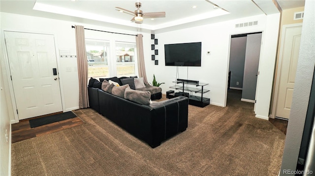 1503 Osage Ave, Fort Morgan, CO 80701 - living area featuring a raised ceiling, ceiling fan, baseboards, and dark colored carpet