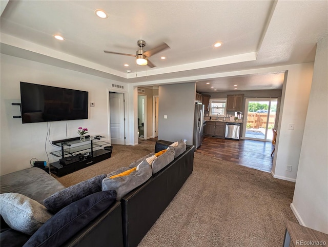 1503 Osage Ave, Fort Morgan, CO 80701 - living area with dark colored carpet, recessed lighting, a ceiling fan, and a tray ceiling