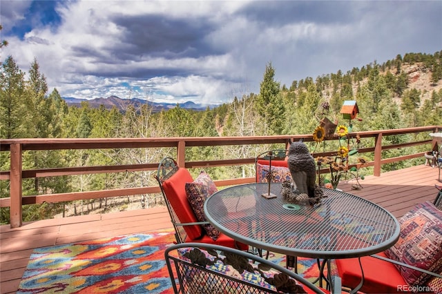 2169 Spruce Rd, Woodland Park, CO 80863 - wooden deck featuring a forest view and outdoor dining space