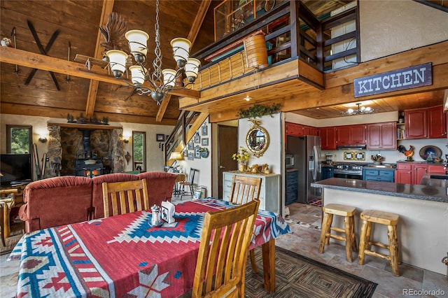 2169 Spruce Rd, Woodland Park, CO 80863 - dining room featuring a wood ceiling with exposed beams, a chandelier, a wood stove, stone finish flooring, and high vaulted ceiling