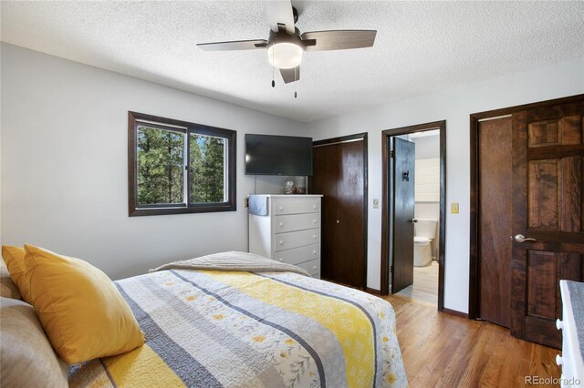 2169 Spruce Rd, Woodland Park, CO 80863 - bedroom featuring light wood-style flooring, a textured ceiling, ensuite bath, and a ceiling fan