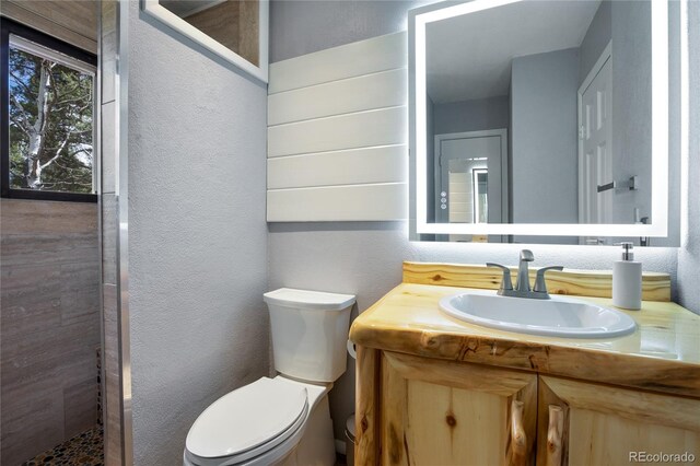 2169 Spruce Rd, Woodland Park, CO 80863 - full bathroom featuring a textured wall, vanity, and a tile shower