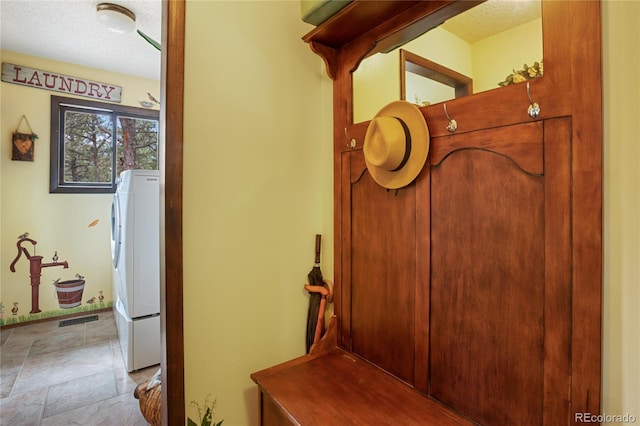 2169 Spruce Rd, Woodland Park, CO 80863 - corridor featuring washer / clothes dryer, a textured ceiling, and stone finish floors