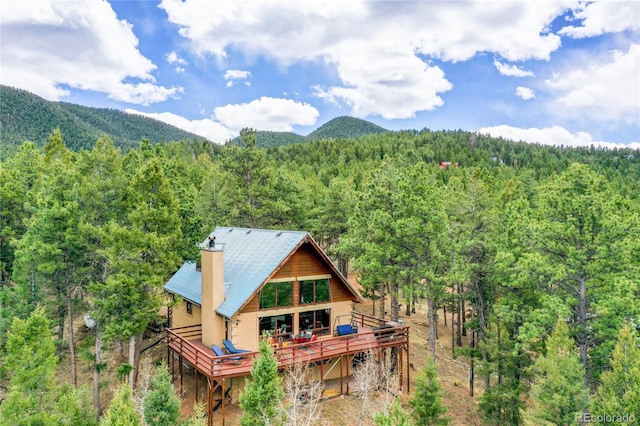 2169 Spruce Rd, Woodland Park, CO 80863 - rear view of house with a wooded view, a metal roof, and a deck with mountain view