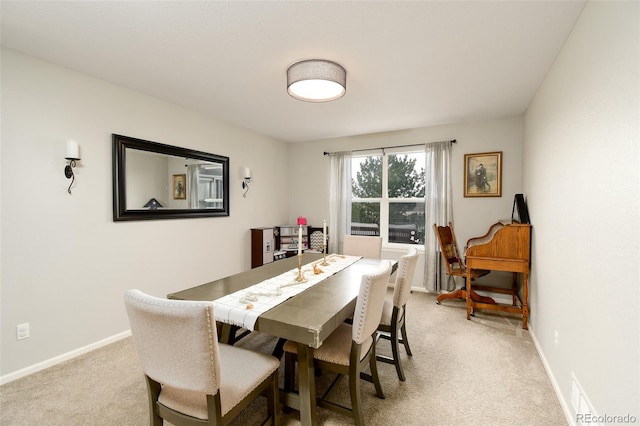 dining area featuring visible vents, baseboards, and light colored carpet