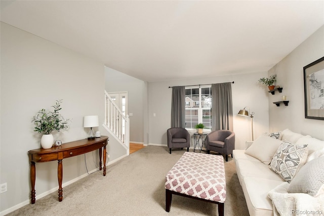 carpeted living room with stairway and baseboards