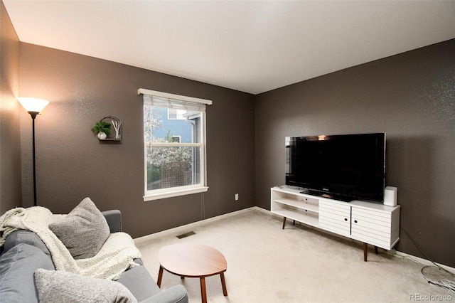 carpeted living room with baseboards, visible vents, and a textured wall