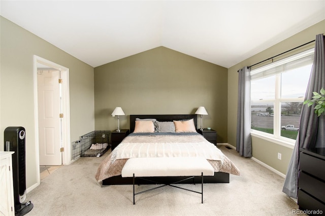 bedroom featuring light colored carpet, vaulted ceiling, and baseboards