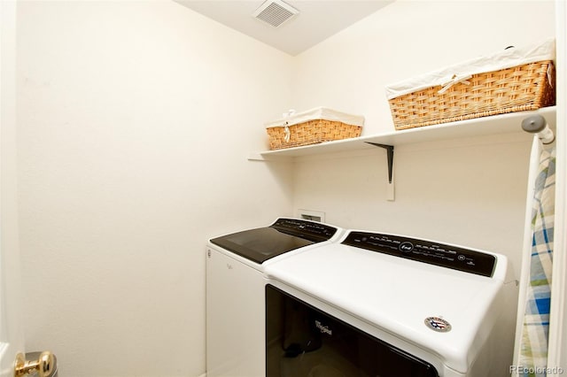 laundry area with visible vents, washer and clothes dryer, and laundry area