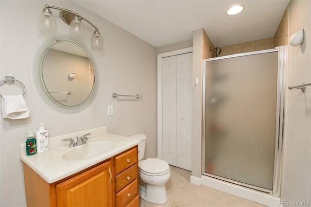 full bathroom featuring a closet, vanity, tile patterned flooring, and a stall shower