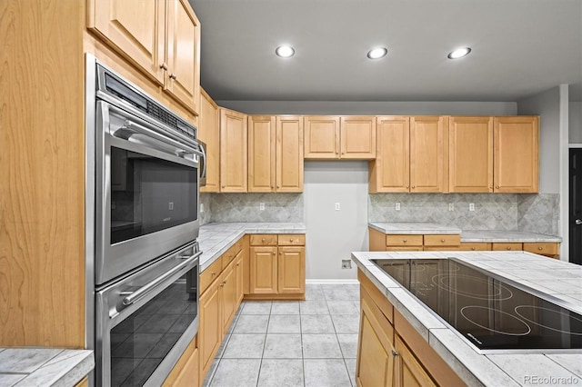 2732 Flint Ct, Superior, CO 80027 - kitchen with black electric stovetop, double oven, recessed lighting, light brown cabinets, and tasteful backsplash