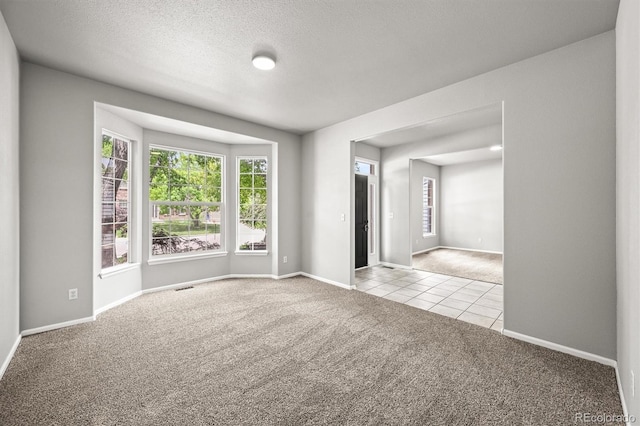2732 Flint Ct, Superior, CO 80027 - carpeted empty room featuring baseboards, tile patterned flooring, and a textured ceiling