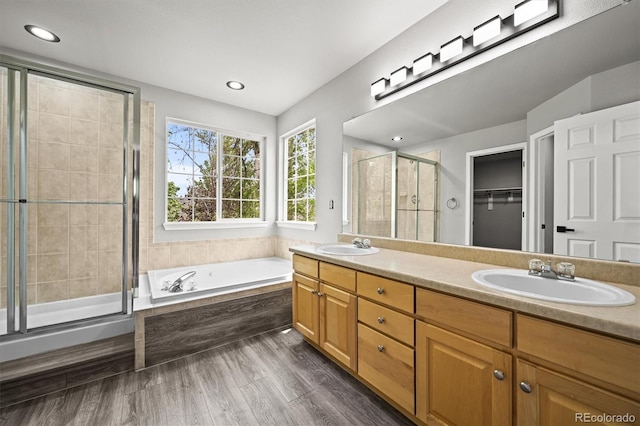 2732 Flint Ct, Superior, CO 80027 - bathroom with a shower stall, a bath, double vanity, wood finished floors, and a spacious closet
