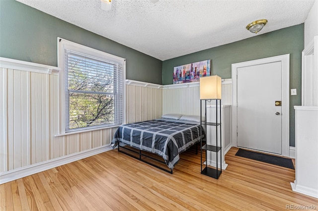 bedroom with wood finished floors and a textured ceiling