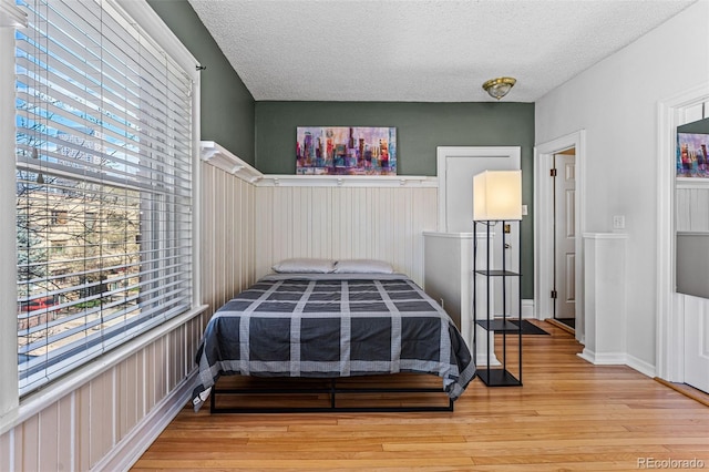 bedroom with light wood finished floors and a textured ceiling