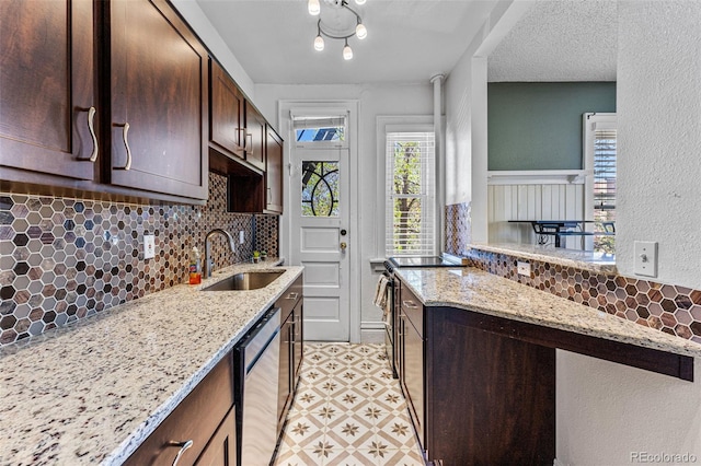 kitchen with a sink, dark brown cabinets, light stone countertops, light floors, and stainless steel dishwasher