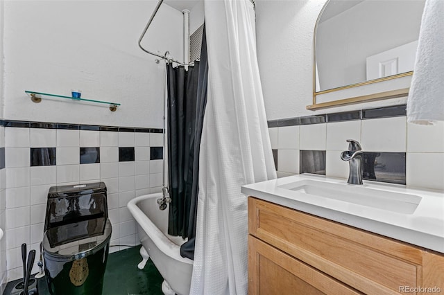 full bathroom with tile walls, vanity, a shower with curtain, and a freestanding tub