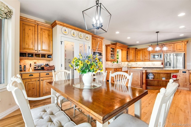 dining area featuring a notable chandelier and light hardwood / wood-style floors