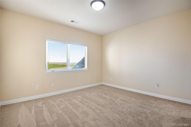 spare room featuring light carpet