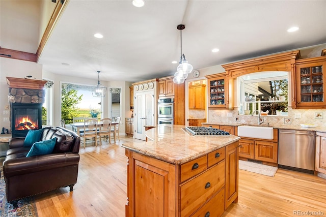 kitchen featuring pendant lighting, stainless steel appliances, tasteful backsplash, and a center island