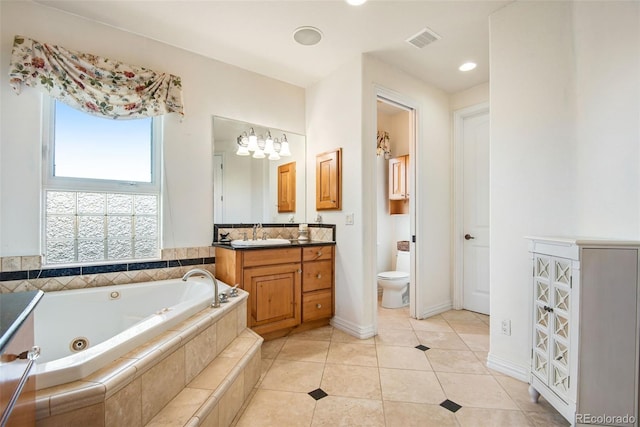 bathroom featuring toilet, vanity, a relaxing tiled bath, and tile flooring