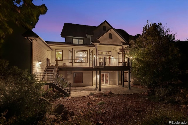 back house at dusk featuring a patio