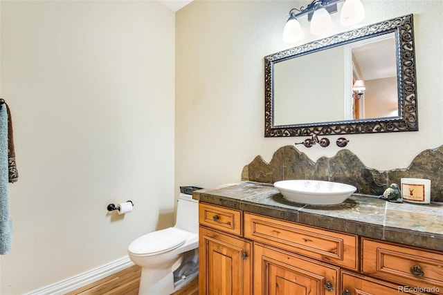 bathroom featuring toilet, vanity, and hardwood / wood-style floors