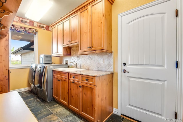 washroom with washer hookup, separate washer and dryer, cabinets, dark tile flooring, and sink