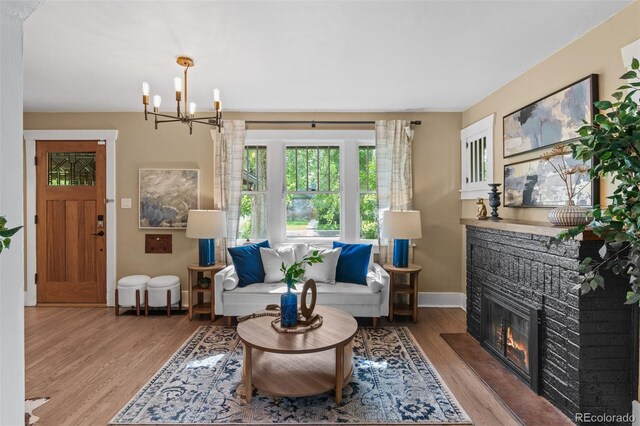 2271 Holly St, Denver, CO 80207 - living area featuring wood finished floors, a chandelier, baseboards, and a fireplace