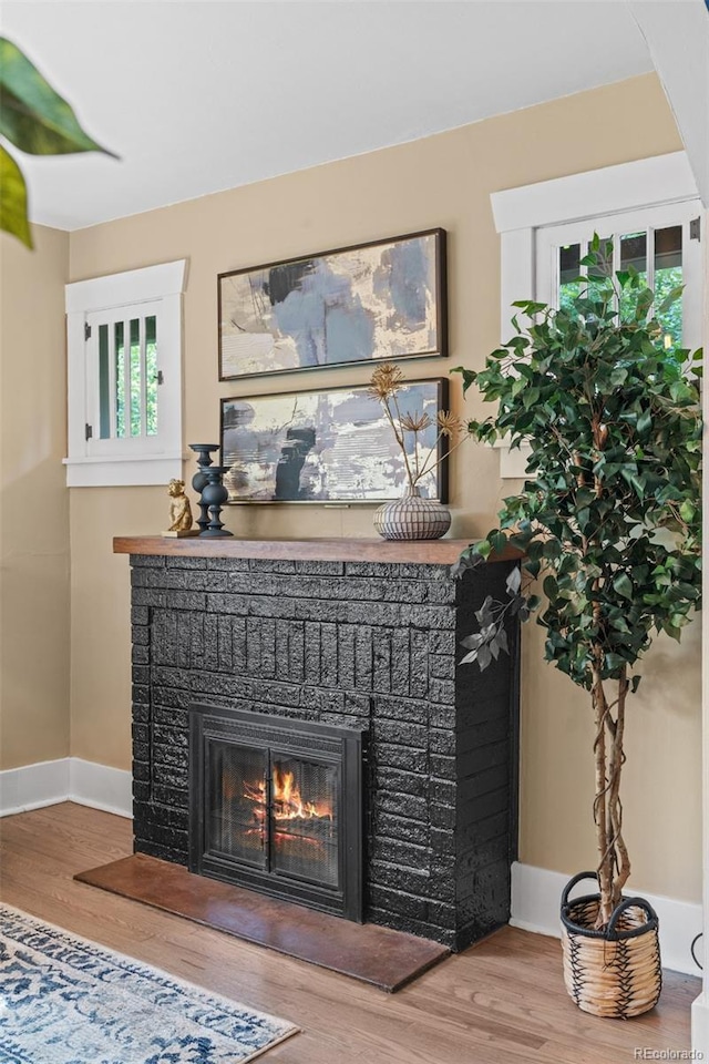 2271 Holly St, Denver, CO 80207 - detailed view of wood finished floors, baseboards, and a brick fireplace