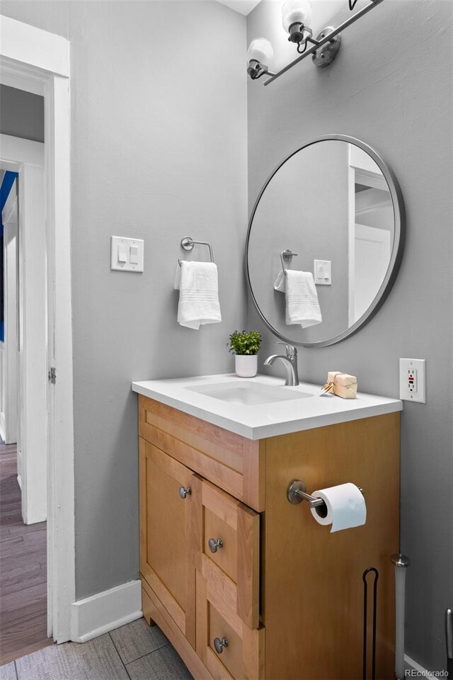 2271 Holly St, Denver, CO 80207 - bathroom with vanity, baseboards, and wood finished floors