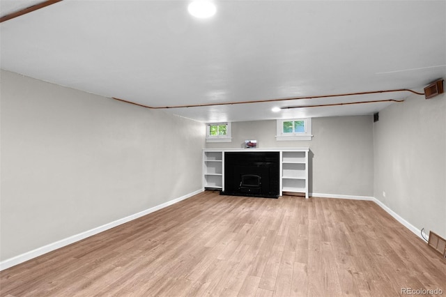 2271 Holly St, Denver, CO 80207 - below grade area featuring light wood-type flooring, a fireplace, and baseboards