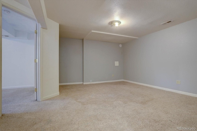 carpeted empty room with a textured ceiling