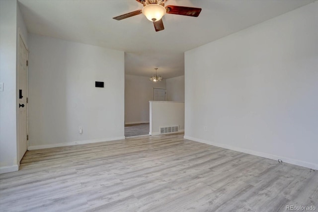 unfurnished room featuring ceiling fan with notable chandelier and light hardwood / wood-style floors