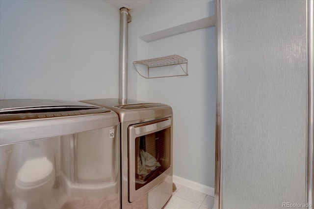 laundry area with washer and clothes dryer and light tile patterned flooring