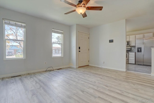 unfurnished living room with ceiling fan and light wood-type flooring