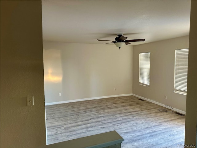 empty room with light hardwood / wood-style floors and ceiling fan