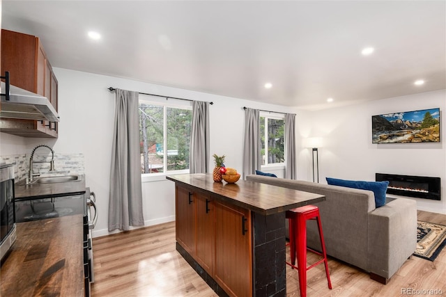 192 Little Creek Rd, Idaho Springs, CO 80452 - kitchen featuring a sink, a glass covered fireplace, light wood-style floors, recessed lighting, and brown cabinetry