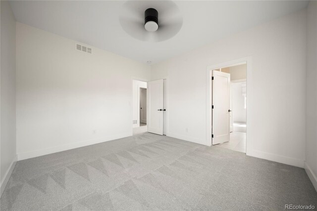 unfurnished bedroom with visible vents, baseboards, carpet flooring, and connected bathroom